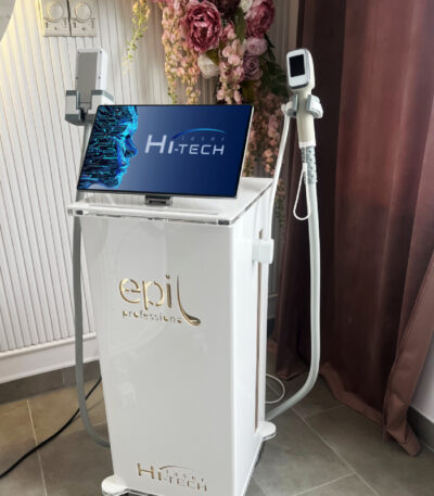 Profesjonalny aparat Hitech do zabiegu laserowego w gabinecie kosmetycznym z kwiatami i burgundowymi zasłonami
